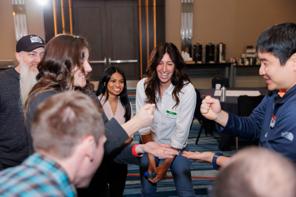 Integral employees playing paper rock scissors at in-person event